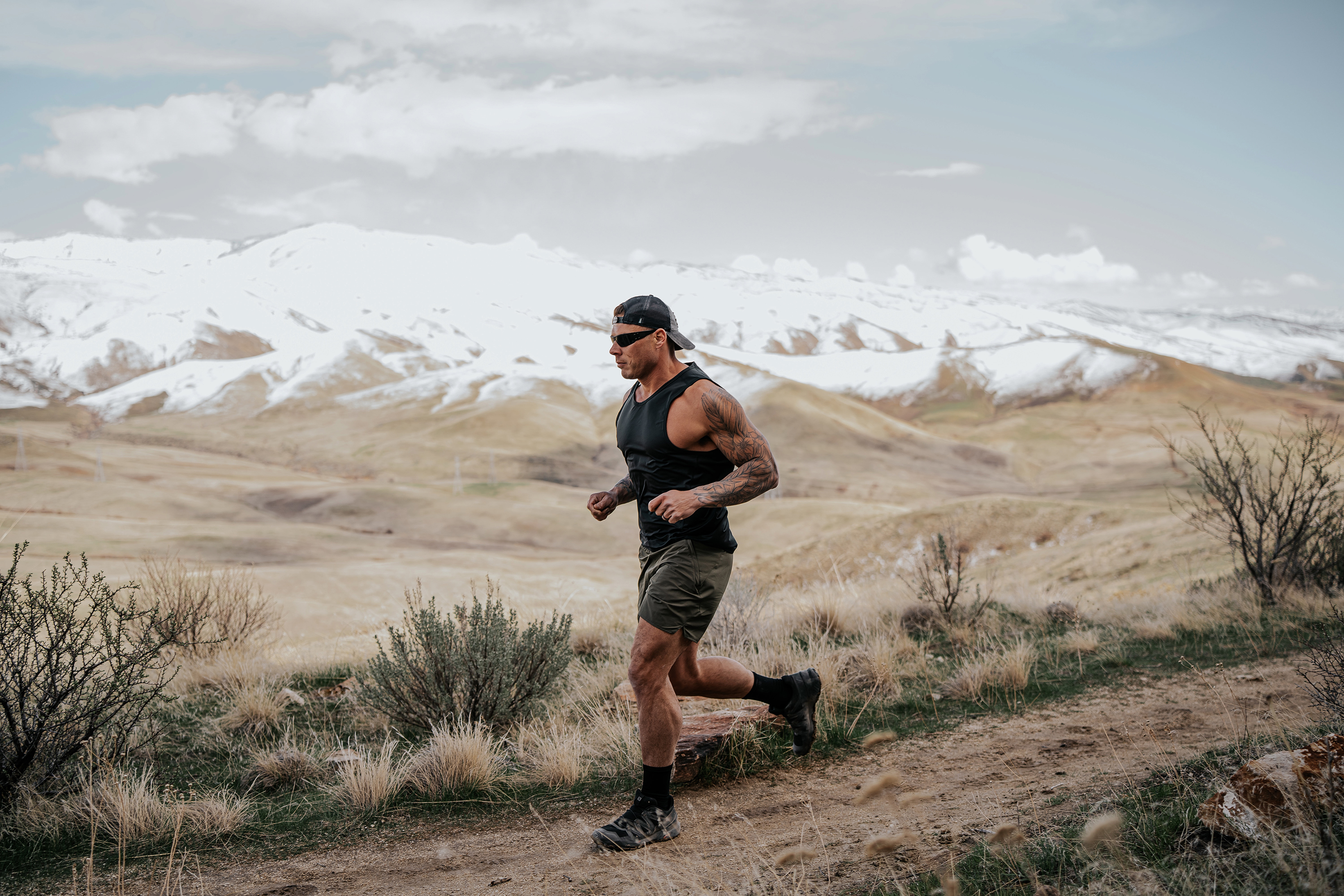 LINEAR Clothing model wearing Baseline Series Tank and shorts running in the mountains